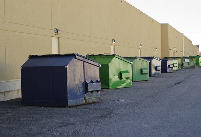 a construction worker unloading debris into a blue dumpster in Brookfield WI